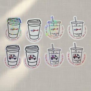 May include: A collection of holographic stickers featuring coffee cups and iced coffee cups. Some stickers have a helicopter or ambulance design. Text on the stickers reads "I run on coffee, chaos, and jet fuel" or "I run on coffee, chaos, and diesel."