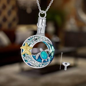 Pode incluir: Colar de prata com um pingente de lua crescente que apresenta uma tartaruga marinha azul e verde e uma estrela do mar dourada. O pingente tem uma pequena abertura para adicionar cinzas ou outras lembranças. O colar vem com um pequeno funil para encher o pingente.
