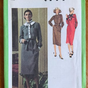 May include: A white ceramic mug with a black handle and the text "But First, Coffee" in a handwritten style. The mug is on a white surface. The mug is approximately 4 inches tall.