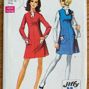 May include: Vintage Simplicity sewing pattern number 8437 for a dress. The pattern is for a size 14, bust 36, and is labeled "New Sizing". The pattern features two illustrations of women wearing the dress in red and blue. The pattern is labeled "easy cut, easy sew" and has 2 or 3 main pattern pieces.