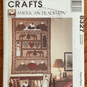 May include: A McCall's Crafts pattern for a quilt featuring a winter scene with a cabin, trees, and snowmen. The pattern is called "American Tradition" and is number 8327. The pattern includes instructions for foundation paper piecing.