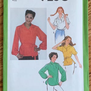 May include: Simplicity sewing pattern number 9260 for a blouse with long sleeves and a tie at the waist. The pattern includes three different styles of blouses, one in red, one in yellow, and one in green.