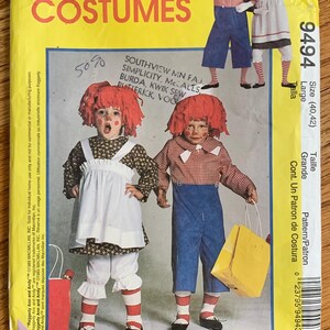 May include: A McCall's Costumes sewing pattern envelope, number 9494, featuring illustrations of children dressed as Raggedy Ann and Andy. The yellow packaging displays the pattern number, size Large (40, 42), and images of the costumes including dresses, pants, and striped socks.