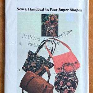May include: Vintage Butterick sewing pattern for handbags. The pattern features four handbag designs, including a tote, a satchel, and a structured bag. The cover shows the bags in various fabrics, with the text "Sew a Handbag in Four Super Shapes".