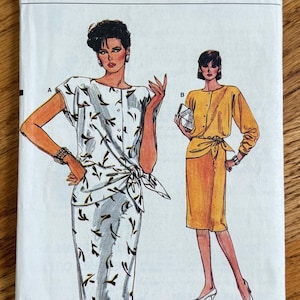 May include: A Very Easy Very Vogue sewing pattern envelope 9316 for sizes 8-10-12. The illustration shows two outfits: a white short-sleeved dress with a black leaf print and a solid yellow long-sleeved dress, both featuring a side-tie waist detail.