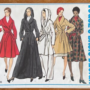 May include: A Vogue's Basic Design sewing pattern envelope, number 2750, featuring illustrations of five different coat styles. The designs include belted coats with shawl collars and hoods in red, black, beige, and a green and red plaid fabric pattern.