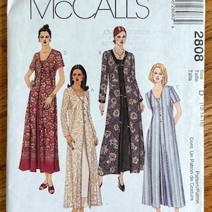 May include: A McCall's 2808 sewing pattern envelope featuring illustrations of four long dresses with button-front overcoats. The designs include a red floral print, a beige paisley print, a dark floral print, and a blue striped pattern, size D 12-14-16.