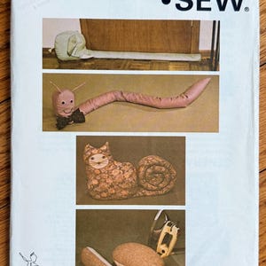 May include: A Kwik Sew pattern envelope, featuring illustrations of stuffed animal designs. The envelope includes a snail, worm, and cat, along with the pattern number 1136 and the Kwik Sew logo.