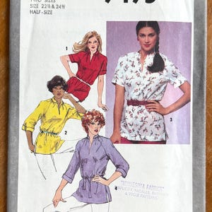 May include: Simplicity sewing pattern 9495, featuring illustrations of blouses in red, yellow, white floral, and purple. The pattern includes two sizes, 22 ½ & 24 ½, and is half-size. The text "Minnesota Fabrics" is also visible.