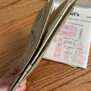 K&ouml;nnte beinhalten: Ein gefaltetes braunes Papier-Schnittmuster mit dem Text "Simplicity Pattern 2568" auf dem Umschlag.