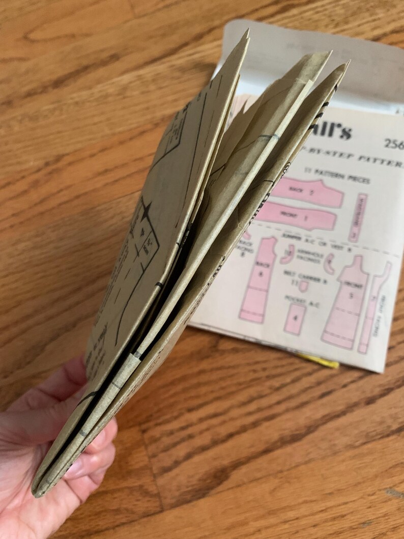 K&ouml;nnte beinhalten: Ein gefaltetes braunes Papier-Schnittmuster mit dem Text "Simplicity Pattern 2568" auf dem Umschlag.