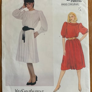 May include: Vogue Patterns Paris Original sewing pattern for a dress with a white and red version. The pattern number is 2989. The designer is Yves Saint Laurent.
