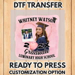 May include: A pink and white DTF transfer design featuring a graduate in a cap and gown, the name "Whitney Watson", and the text "2X Graduate Luminary High School". The design includes a photo and a heart-shaped balloon.