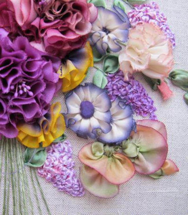 May include: A close-up of a colorful silk ribbon embroidery bouquet. The bouquet features purple, pink, yellow, and white flowers with green leaves. The flowers are made of silk ribbon and are arranged in a realistic style.