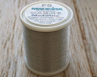 May include: A spool of silver metallic embroidery thread from Madeira, made in Germany. The label reads "FS. MADEIRA made in germany Metallic Stickgarn Embroidery Thread Filato da ricamo Fil à broder Hilo para bordar nakış ipliği".