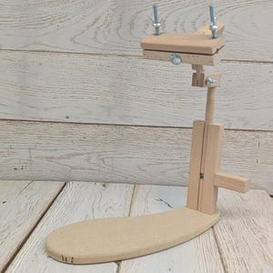 以下が含まれることがあります： ベースと高さ調節可能な木製刺繍スタンド。スタンドには生地を保持するためのクランプが付いています。