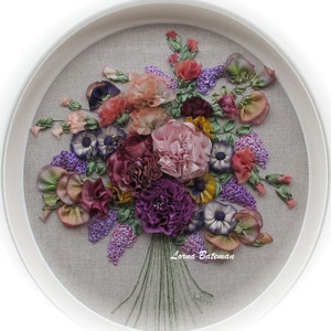 May include: A framed embroidery of a colorful silk ribbon bouquet with pink, purple, and yellow flowers. The artist's signature, "Lorna Bateman", is visible in the bottom right corner.