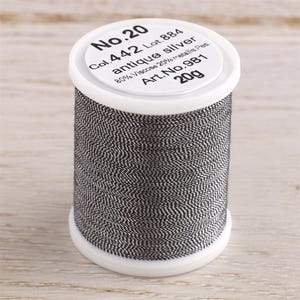 May include: A spool of No. 20 antique silver thread, labeled "Col. 442 Lot. 884 antique silver 80% Viscose 20% metallic Pes. Art. No. 981 20g".