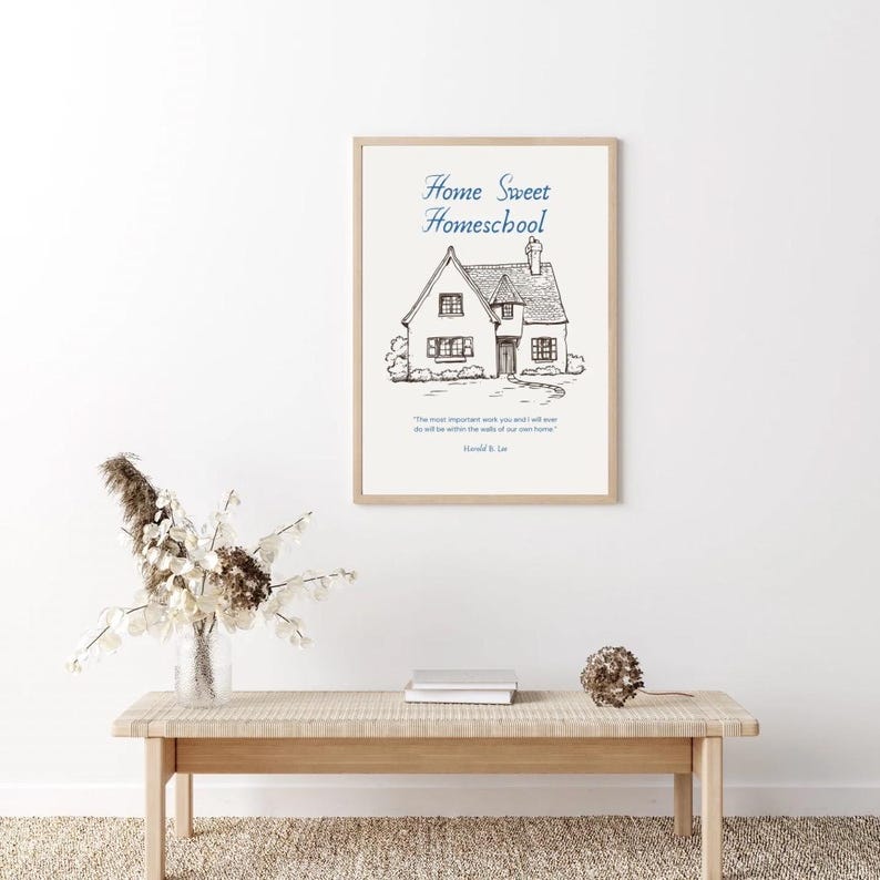 May include: A framed print with the words "Home Sweet Homeschool" above a detailed sketch of a house. The print includes a quote and the name "Harold B. Lee" at the bottom. The frame is a light wood color.