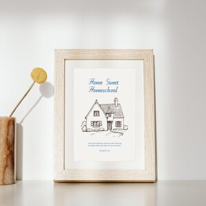 May include: A framed print with the words "Home Sweet Homeschool" above a detailed pen and ink drawing of a house. The frame is light wood. A quote by Harold B. Lee is below the house illustration.