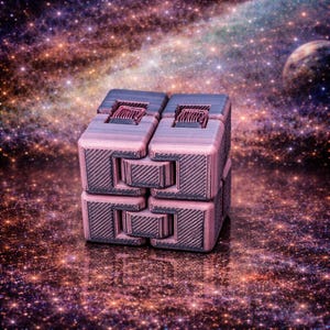 May include: A multi-colored, 3D-printed fidget toy with a complex, interlocking design. The toy is primarily pink and gray, with a textured surface. The background features a galaxy-themed design with stars and planets.