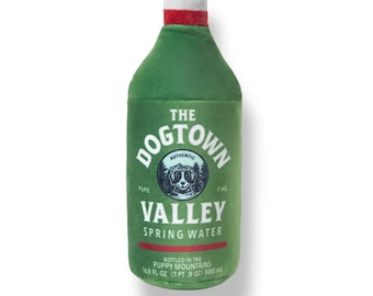 May include: A green plush dog toy shaped like a water bottle, with a white top and red band. The label reads "THE DOGTOWN VALLEY SPRING WATER" with a dog logo. It is labeled as 14.9 fl oz (1 pt 9 oz) 500 ml.