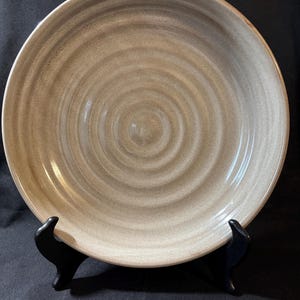 May include: A white ceramic mug with a colorful floral design. The mug features a handle and a wide rim. The flowers are in shades of pink, purple, and yellow. The mug is likely for hot beverages.