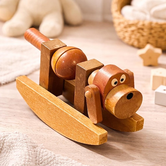 A mid-century folk-art rocking dog with real kinetic movement — looks like something you'd find in a cool vintage shop, not a mass-market store.