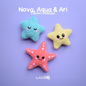 May include: Three crocheted plush toys in the shape of stars. A blue star, a yellow star, and a pink starfish. Each star has a smiling face with black eyes and pink cheeks. The text "Nova, Aqua & Ari Pattern Release" is above the stars. The text "wooliie" is below the stars.