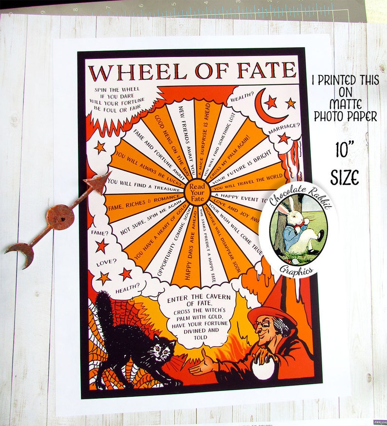 May include: A vintage-style wheel of fate fortune teller print featuring a black cat and a witch. The wheel has a colourful design with orange, yellow, and red colours. The text on the wheel reads "Wheel of Fate" and "Read Your Fate". The print is 10 inches in size and printed on matte photo paper.