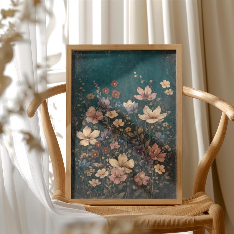 May include: A framed floral print featuring a variety of flowers in shades of pink, yellow, and purple against a dark teal background. The artwork is displayed on a wooden chair, with a white curtain in the background.