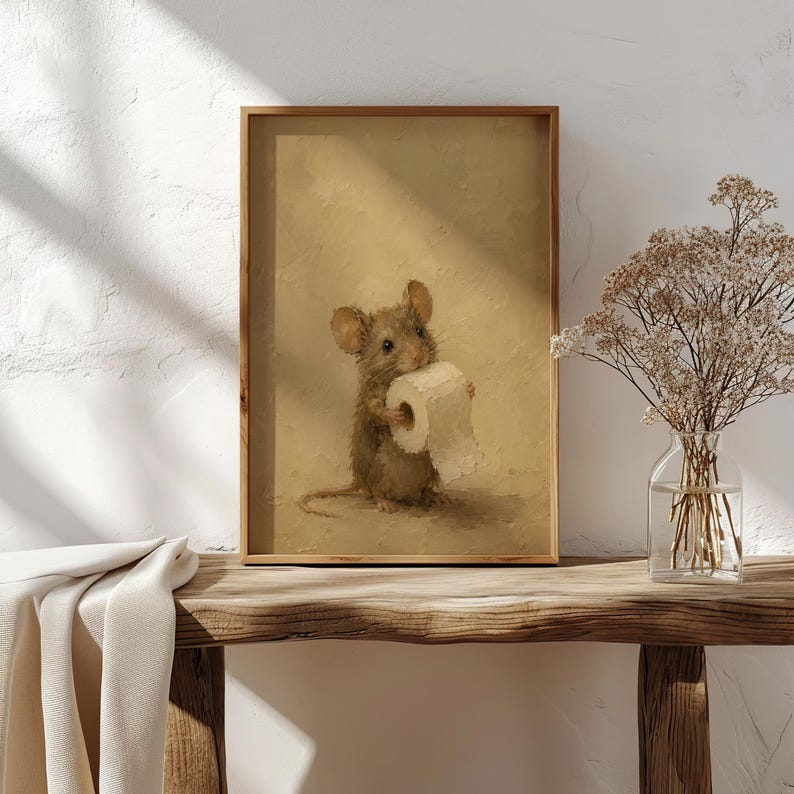 May include: A framed wall art print featuring an oil painting of a small brown mouse holding a white roll of toilet paper. The mouse is centered against a textured, monochromatic beige background, rendered with visible brushstrokes.