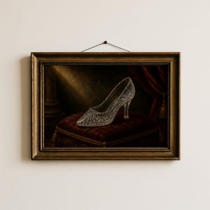 Pu&ograve; includere: Una stampa artistica da parete incorniciata che raffigura una scarpa con tacco in vetro trasparente sfaccettato appoggiata su un cuscino di velluto rosso scuro. La scena &egrave; ambientata su uno sfondo scuro con un raggio di luce che illumina la scarpa.