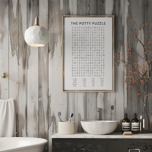 May include: A framed word search puzzle titled "The Potty Puzzle" hangs on a wooden wall. The bathroom scene includes a white sink, a decorative light fixture, and a vase with branches. The puzzle's words are related to bathroom activities.