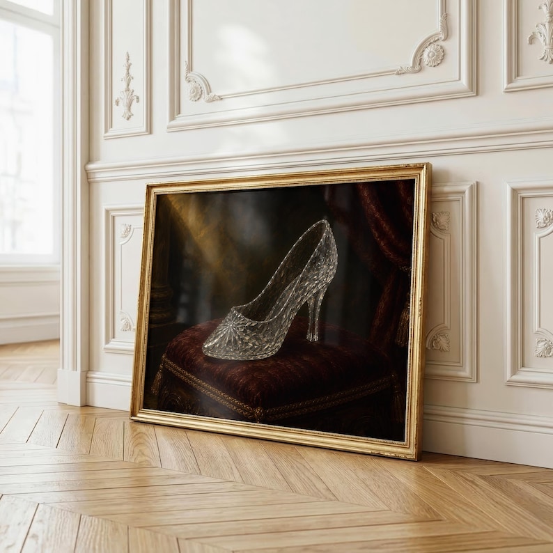 Pu&ograve; includere: Una stampa artistica incorniciata raffigurante una scarpa con tacco trasparente e sfaccettata appoggiata su una sedia imbottita rosso scuro. La scarpa presenta una punta affilata e un tacco sottile, con una superficie testurizzata che cattura la luce. La cornice &egrave; dorata.