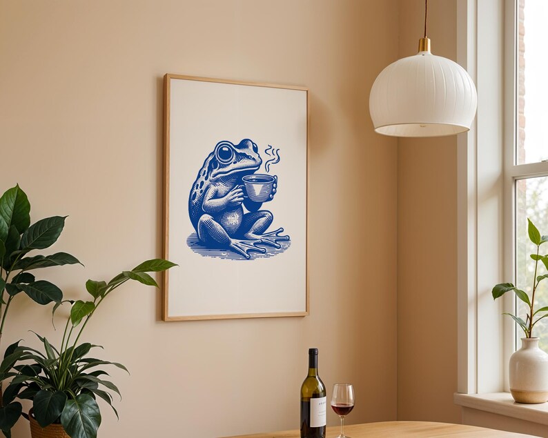 May include: A blue and white illustration of a frog sitting on a white background, holding a cup of coffee. The frog is wearing a blue shirt and has a blue hat. The frog is sitting on a white background.