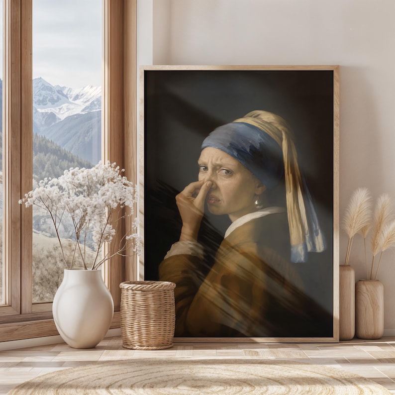 May include: A framed wall art print depicting a person wearing a blue headscarf and brown garment, holding their nose with one hand. The person has a facial expression of disgust. The artwork is set against a dark background with light streaks.