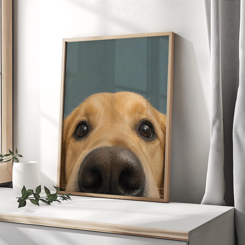 Puede incluir: Una impresi&oacute;n de arte mural enmarcada que presenta una ilustraci&oacute;n en primer plano de la cara de un perro golden retriever. El perro tiene pelaje dorado claro, ojos marr&oacute;n oscuro y una nariz oscura grande y prominente centrada en un fondo azul.