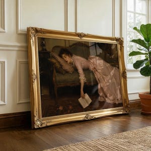 May include: A large rectangular painting in an ornate gold frame depicting a person in a long pink dress reclining on a dark green upholstered sofa. The person is resting their head on a pillow and holding an open book that hangs toward the floor.