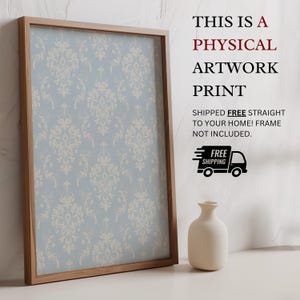 May include: A rectangular wooden frame containing a light blue print with a repeating white damask pattern. To the right, text reads: THIS IS A PHYSICAL ARTWORK PRINT SHIPPED FREE STRAIGHT TO YOUR HOME! FRAME NOT INCLUDED. A small white vase sits below.