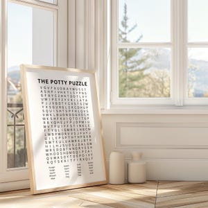 May include: A framed vertical poster titled THE POTTY PUZZLE featuring a black and white word search grid with bathroom-themed terms listed at the bottom, including Plunger, Splash, Sniff, Bubble, Gurgle, Squirt, Poop, Tinkle, Squish, Flush, Plop, Whiff, Whoosh, Drip, Toot, Fizzy, Wipe, Clog, Pee, Suds.