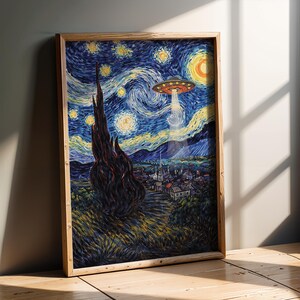 May include: A framed print of a painting depicting a starry night sky with a UFO beaming a light down on a village. The artwork is in the style of Van Gogh, with swirling brushstrokes and vibrant colors. The frame is made of light-colored wood.