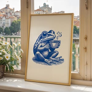 May include: A blue and white illustration of a frog holding a steaming cup of coffee in a gold frame.