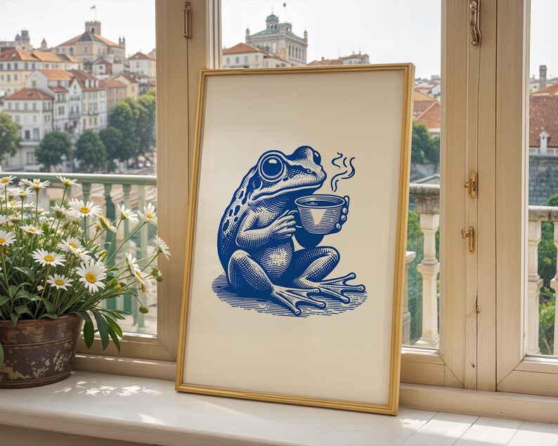 May include: A blue and white illustration of a frog holding a steaming cup of coffee in a gold frame.