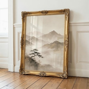 May include: A large rectangular wall art piece featuring a landscape painting of misty mountains and a lone tree, encased in an ornate, decorative gold-colored frame with intricate carved details along the edges and corners of the frame.