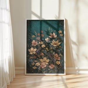 May include: A framed floral print featuring a variety of flowers in shades of yellow, pink, and purple against a dark teal background. The artwork is displayed on a wooden floor, with sunlight casting shadows from a nearby window.