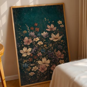 May include: A framed floral print featuring a dark teal background with a variety of flowers in shades of pink, purple, and white. The artwork is displayed in a room with a wooden stool and a bed.