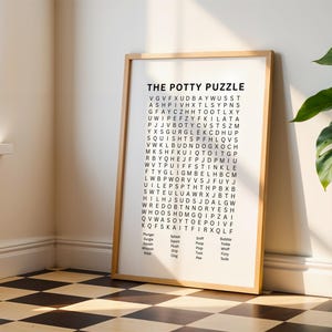May include: A framed wall art print titled THE POTTY PUZZLE featuring a word search grid with black letters on a white background. Below the grid, a list of words including Plunger, Gurgle, Squish, Whoosh, Wipe, Splash, Squirt, Flush, Drip, Clog, Sniff, Poop, Plop, Toot, Pee, Bubble, Tinkle, Whiff, Fizzy, and Suds.