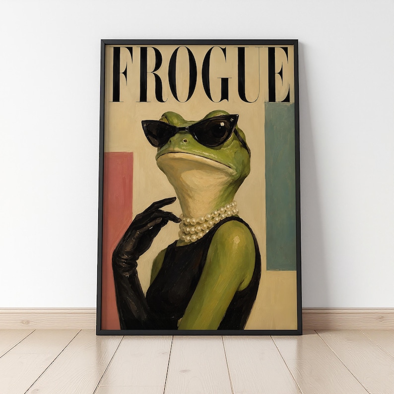 May include: A framed wall art print featuring a green frog wearing black cat-eye sunglasses, a multi-strand pearl necklace, and a black sleeveless top with a long black glove. The word FROGUE is printed in large black serif letters at the top.