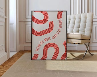 Könnte beinhalten: Gerahmter Kunstdruck mit schwarzem Rand. Der Druck zeigt rote wellenförmige Linien und den Text "DREAM BIG WORK HARD STAY HUMBLE" in Rot. Das Kunstwerk wird in einem Raum mit beigem Teppich und weißem Stuhl ausgestellt.